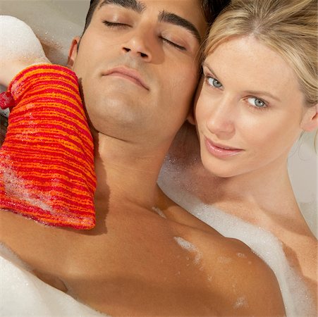 Close-up of a young woman scrubbing a young man's chest with a bath sponge Stock Photo - Premium Royalty-Free, Code: 625-00900863