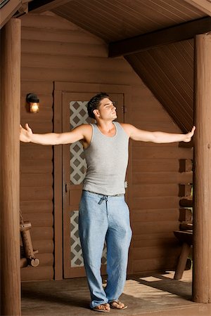 porch swing images - Young man standing with his arms outstretched Stock Photo - Premium Royalty-Free, Code: 625-00901163