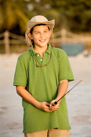 photos of little boy fishing - Close-up of a teenage boy holding a fishing rod Foto de stock - Sin royalties Premium, Código: 625-00901997