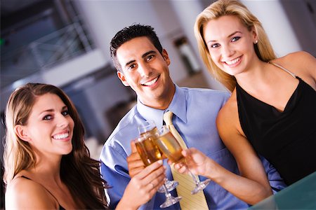 simsearch:625-00902698,k - Portrait of a mid adult man and two young women raising a toast Foto de stock - Sin royalties Premium, Código: 625-00902705