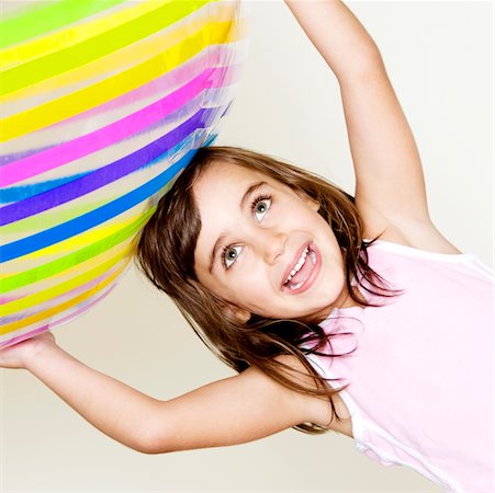 Close-up of a girl holding a ball over her head Stock Photo - Premium Royalty-Free, Code: 625-00902793