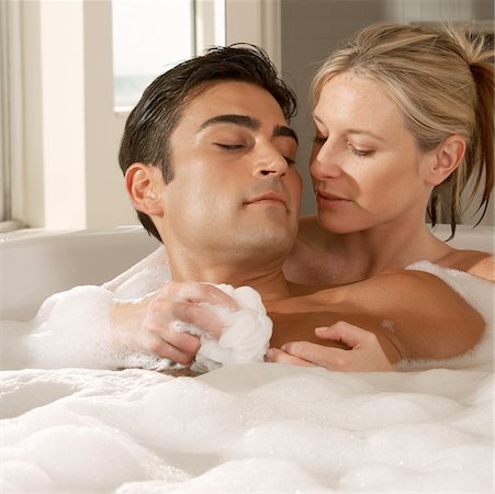 Close-up of a young woman scrubbing a young man's chest with a bath sponge Stock Photo - Premium Royalty-Free, Code: 625-00903034