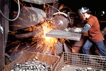 foundry worker - Side profile of a foundry worker working on a metal saw in a factory, Wisconsin, USA Stock Photo - Premium Royalty-Free, Code: 625-00903843