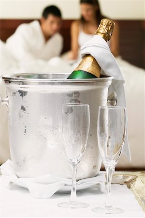 Close-up of a champagne bottle in an ice bucket with two champagne flutes Stock Photo - Premium Royalty-Free, Code: 625-01038796