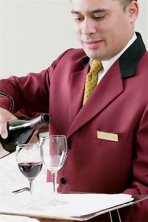 Close-up of a waiter pouring red wine into wineglasses Stock Photo - Premium Royalty-Free, Code: 625-01038799