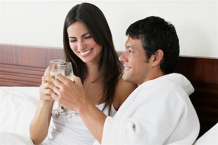 Close-up of a young woman and a mid adult man toasting with champagne flutes Stock Photo - Premium Royalty-Free, Code: 625-01038852