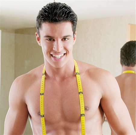 Portrait of a young man with a tape measure around his neck Stock Photo - Premium Royalty-Free, Code: 625-01038883