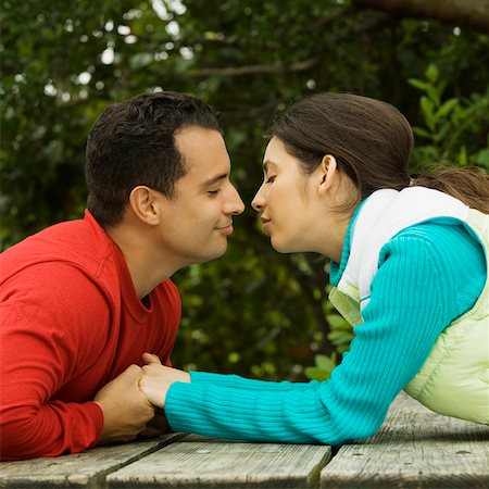 simsearch:625-01092421,k - Side profile of a young couple holding hands and kissing Stock Photo - Premium Royalty-Free, Code: 625-01039122
