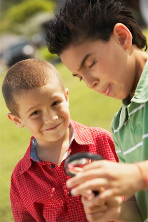 Portrait of a boy and his friend holding a magnifying glass Stock Photo - Premium Royalty-Free, Code: 625-01039145