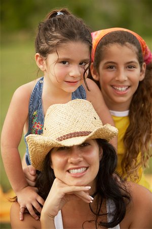 Portrait of a young woman posing with her two daughters with her hand on her chin Stock Photo - Premium Royalty-Free, Code: 625-01039444