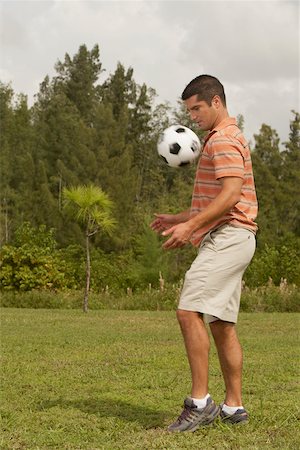football ball american - Side profile of a mid adult man playing with a soccer ball Stock Photo - Premium Royalty-Free, Code: 625-01039597