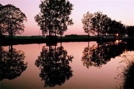 peace silhouette in black - Silhouetted trees being reflected in the Bungundy Canal, France Stock Photo - Premium Royalty-Free, Code: 625-01040636
