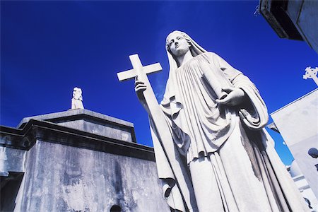 Low angle view of a statue of Virgin Mary with a cross Stock Photo - Premium Royalty-Free, Code: 625-01094724