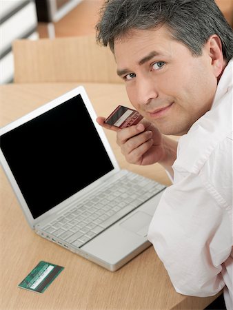 simsearch:625-00801205,k - Portrait of a mature man holding a credit card Stock Photo - Premium Royalty-Free, Code: 625-01097473