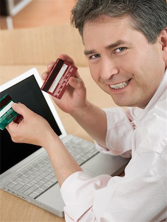 simsearch:625-00801205,k - Portrait of a mature man holding two credit cards and smiling Stock Photo - Premium Royalty-Free, Code: 625-01097486