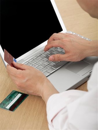 simsearch:625-00801205,k - Close-up of a mature man's hand holding a credit card and using a laptop Stock Photo - Premium Royalty-Free, Code: 625-01097488