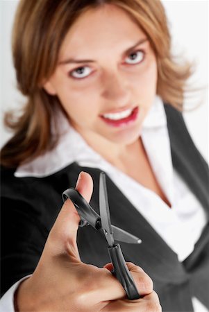 simsearch:625-01097830,k - Portrait of a businesswoman holding a pair of scissors and clenching her teeth Stock Photo - Premium Royalty-Free, Code: 625-01097551