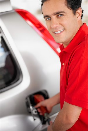 Portrait of a young man refueling a car Stock Photo - Premium Royalty-Free, Code: 625-01097605