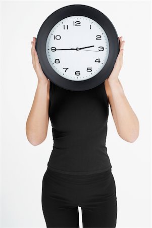 simsearch:625-01097830,k - Businesswoman hiding her face with a clock Stock Photo - Premium Royalty-Free, Code: 625-01097807