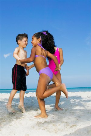 Two girls and a boy playing on the beach Stock Photo - Premium Royalty-Free, Code: 625-01098108