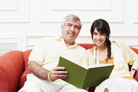 simsearch:625-01092421,k - Portrait of a mature man sitting with his daughter on a couch and holding a book Stock Photo - Premium Royalty-Free, Code: 625-01092774