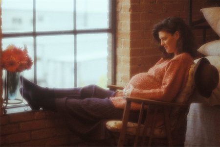 Profil de côté d'une femme enceinte assise sur une chaise et toucher son abdomen Photographie de stock - Premium Libres de Droits, Code: 625-01093018