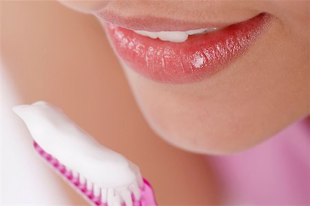 prophylaxis - Gros plan d'une jeune femme avec une brosse à dents devant sa bouche Photographie de stock - Premium Libres de Droits, Code: 625-01093389