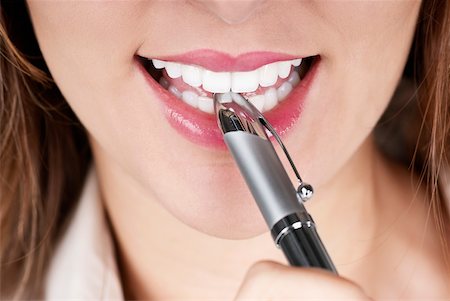 simsearch:625-01097830,k - Close-up of a businesswoman smiling with a pen on her lips Stock Photo - Premium Royalty-Free, Code: 625-01093718