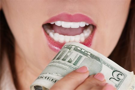 simsearch:625-01097830,k - Close-up of a businesswoman holding a bundle of dollar bills near her mouth Stock Photo - Premium Royalty-Free, Code: 625-01093724