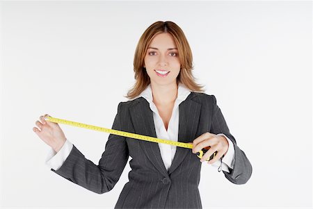 simsearch:625-01097830,k - Portrait of a businesswoman holding a measuring tape and smiling Stock Photo - Premium Royalty-Free, Code: 625-01093732