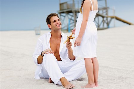 Young man giving a starfish to his daughter Stock Photo - Premium Royalty-Free, Code: 625-01093945