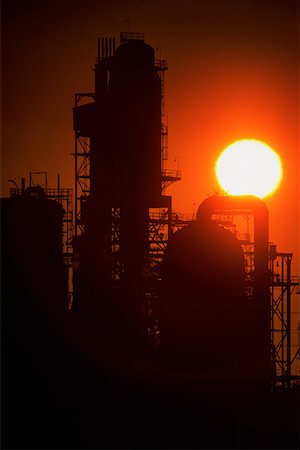 Chemical refinery plant and smokestacks in silhouette Stock Photo - Premium Royalty-Free, Code: 625-01249682