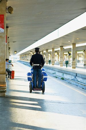 scooter rear view - Rear view of two policemen traveling on scooters at a railroad station platform, Rome, Italy Stock Photo - Premium Royalty-Free, Code: 625-01249903
