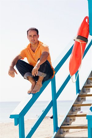 simsearch:625-00903103,k - Portrait of a mid adult man sitting on the hand rail of a lifeguard hut and smiling Stock Photo - Premium Royalty-Free, Code: 625-01249932
