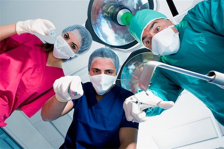 simsearch:625-01249642,k - Low angle view of two male surgeons and a female surgeon holding surgical equipments Foto de stock - Sin royalties Premium, Código: 625-01250231