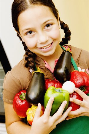 Portrait of a girl holding vegetables and smiling Stock Photo - Premium Royalty-Free, Code: 625-01250657