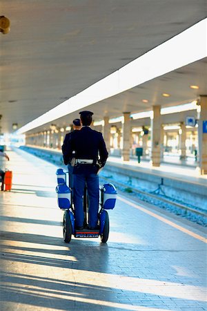 scooter rear view - Rear view of two policemen traveling on scooters at a railroad station platform, Rome, Italy Stock Photo - Premium Royalty-Free, Code: 625-01250757