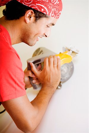 electric saw - Side profile of a young man working with a circular saw Stock Photo - Premium Royalty-Free, Code: 625-01250855