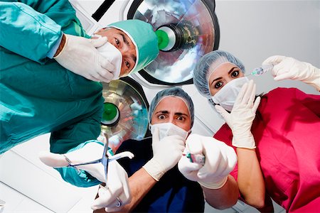simsearch:625-01249642,k - Low angle view of two male surgeons and a female surgeon looking surprised Foto de stock - Sin royalties Premium, Código: 625-01250884
