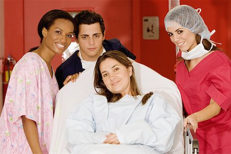 sick black woman - Two female doctors and a male doctor pushing a female patient on a hospital gurney Stock Photo - Premium Royalty-Free, Code: 625-01251094