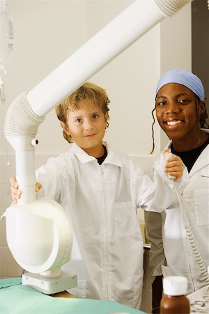 simsearch:625-01249642,k - Portrait of a boy imitating a doctor and operating an X-Ray machine with a female doctor standing beside him Foto de stock - Sin royalties Premium, Código: 625-01251115