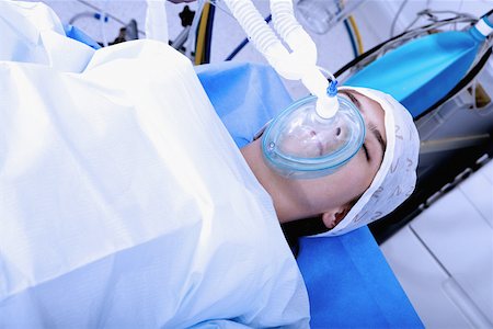 patient oxygen breathing - High angle view of a female patient lying on an operating table Stock Photo - Premium Royalty-Free, Code: 625-01251670