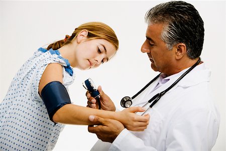 Side profile of a male doctor measuring blood pressure of a young woman Stock Photo - Premium Royalty-Free, Code: 625-01251815