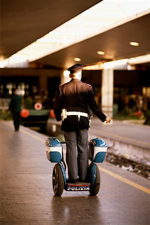scooter rear view - Rear view of a policeman on a scooter at a railroad station platform, Rome, Italy Stock Photo - Premium Royalty-Free, Code: 625-01251900