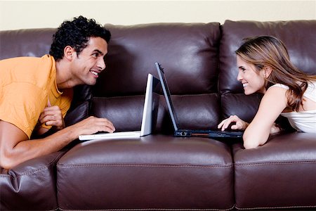 simsearch:625-01092421,k - Side profile of a young couple lying on a couch and using laptops Stock Photo - Premium Royalty-Free, Code: 625-01252207