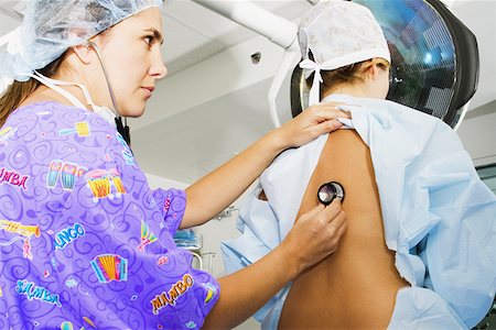 simsearch:625-01249642,k - Side profile of a female doctor examining a female patient with a stethoscope Foto de stock - Sin royalties Premium, Código: 625-01252358