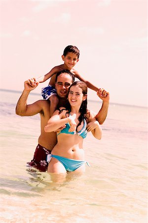 simsearch:625-01748893,k - Mid adult man carrying his son on his shoulders with a young woman standing in front of him on the beach Stock Photo - Premium Royalty-Free, Code: 625-01252375