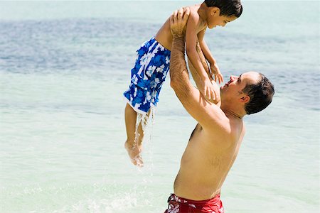 simsearch:625-01748893,k - Side profile of a mid adult man picking up his son in water Stock Photo - Premium Royalty-Free, Code: 625-01252491