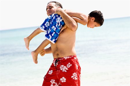 simsearch:625-01748893,k - Side profile of a mid adult man carrying his son on his shoulders on the beach Stock Photo - Premium Royalty-Free, Code: 625-01252507