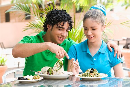 Close-up of a young man and a teenage girl sitting at a table in a restaurant Stock Photo - Premium Royalty-Free, Code: 625-01264086